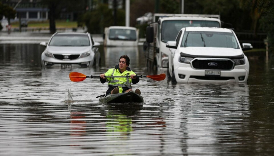 En mand i kajak sejler rundt mellem bilerne i Sydney. En mand i kajak sejler rundt mellem bilerne i Sydney.