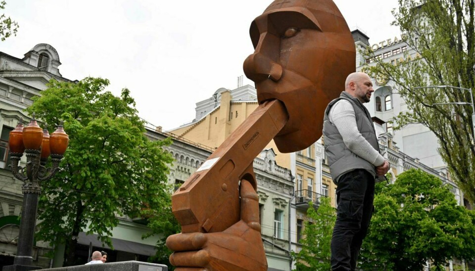 Den ukrainske skulptør Dmytro Iv. taler med journalister foran hans monument, der viser Ruslands præsident Vladimir Putin med en pistol i munden, og kaldes 'Skyd dig selv' i centrum af Kyiv den 7. maj.