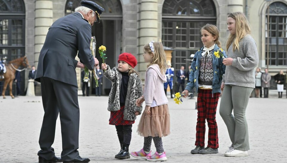 Fødselaren tager imod blomster fra nogle fremmødte børn på pladsen foran slottet i Stockholm.