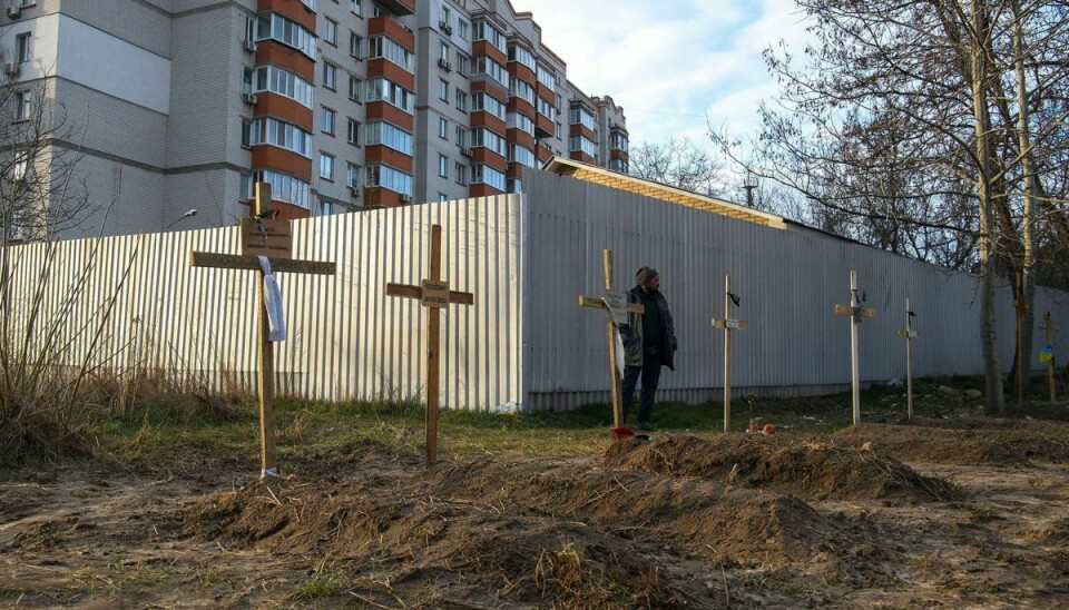 En mand ses her ved siden af en række grave med civile i byen Butja i Ukraine mandag. Ifølge lokale beboere blev de civile dræbt af russiske soldater.