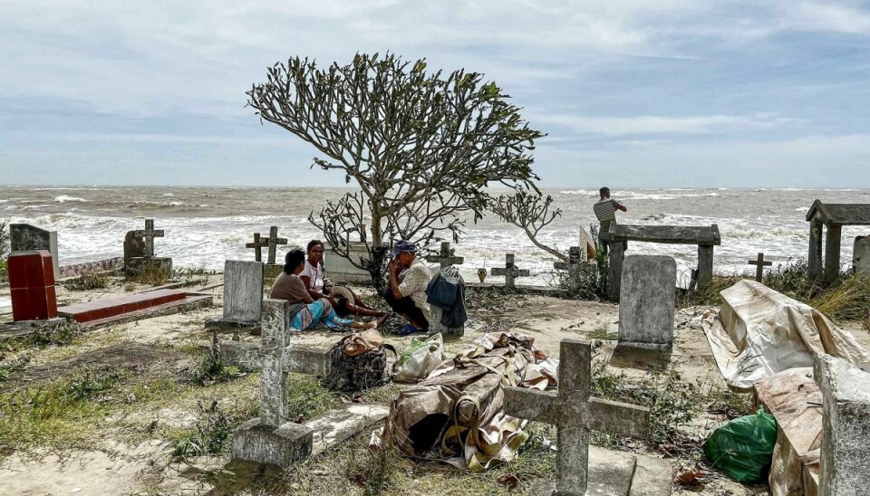 Pårørende sidder ved siden af nogle af de lig, der blev skyllet ud af deres grave på den lokale kirkegård i byen Mahanoro. Kirkegården ligger ud til havet, og de kraftige bølger fjernede meget af den sandede jord, de afdøde var begravet under. Pårørende sidder ved siden af nogle af de lig, der blev skyllet ud af deres grave på den lokale kirkegård i byen Mahanoro. Kirkegården ligger ud til havet, og de kraftige bølger fjernede meget af den sandede jord, de afdøde var begravet under.