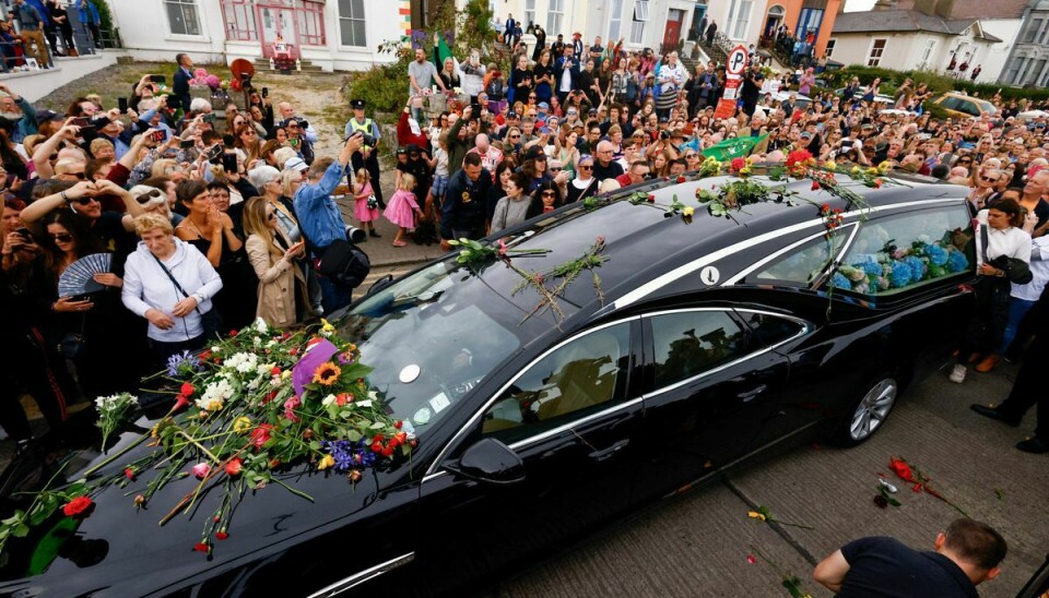 Rustvognen med Sinéad O'Connors kiste sese her køre ad strandpromenaden i Bray omgivet at tusinder af fans, der ville sige et sidste farvel.