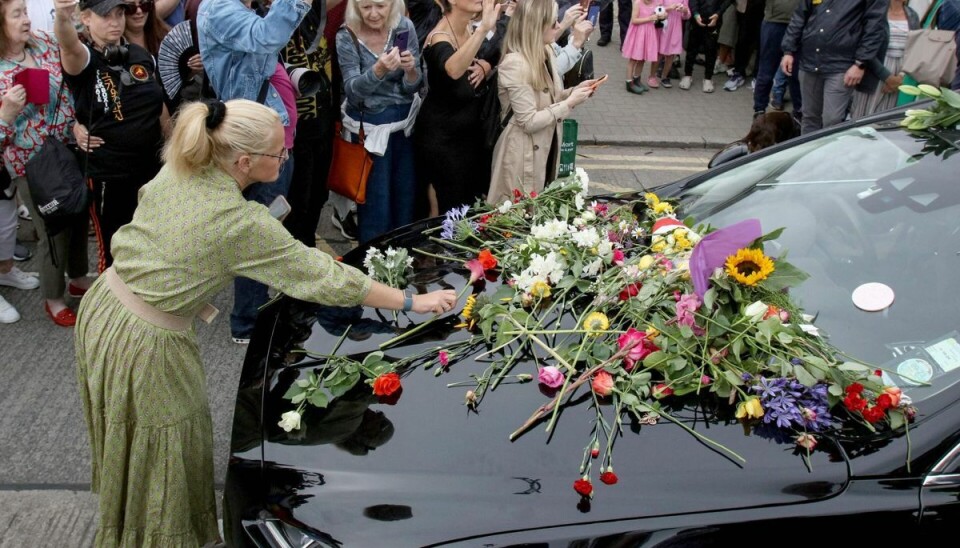 Adskillige fans lagde blomster på rustvognen, da den kørte forbi med kisten Adskillige fans lagde blomster på rustvognen, da den kørte forbi med kisten