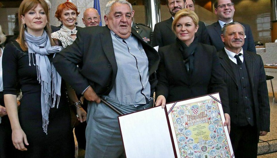 Menneskerettighedsforkæmper Ivan Zvonimir Cicak’s (midten) har netop fået trukket bukserne op, mens Kroatiens præsident fremviser den pris, Cicak netop har modtaget. Klik videre og se Cicak tabe bukserne. Foto: Scanpix