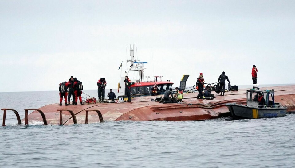 Dykkere og redningsfolk arbejder på kæntrede 'Karin Høj'. I skroget fandt dykkerne liget af en sømand.