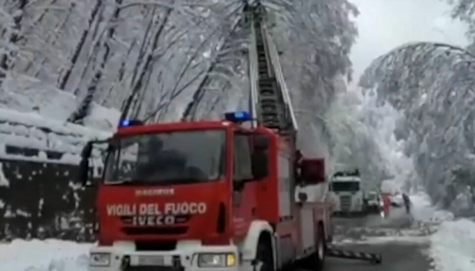 Italienske brandmænd er her i gang med at fjerne nedfaldne trægrene for at forsøge at åbne vejen.