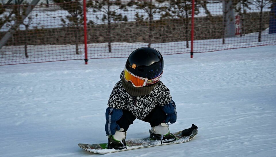 Baby på boardet Hun kan ikke gå. Men snowboardet volder ikke det store besvær.