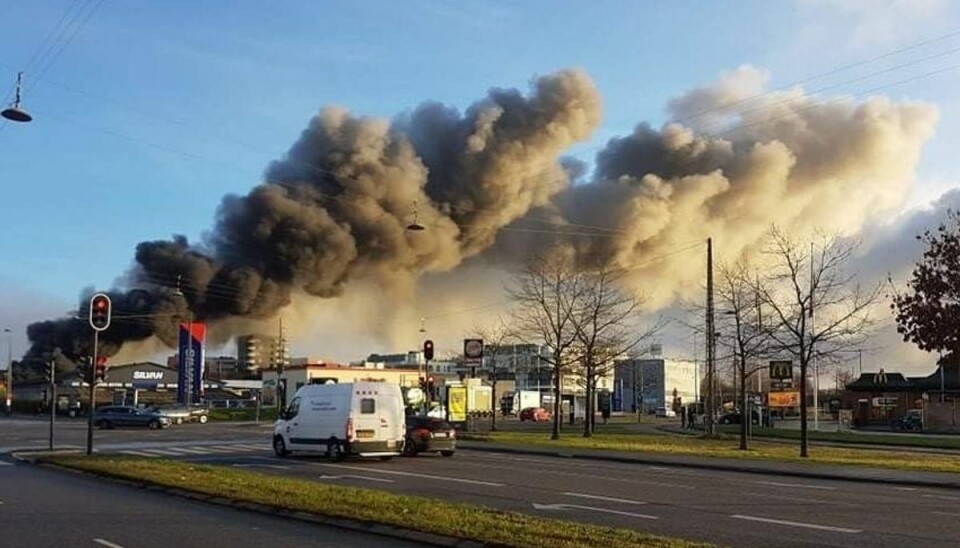 Flammerne har godt fat i forretningen. Det ryger voldsomt fra branden.