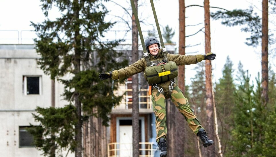 En storsmilende prinsesse Ingrid Alexandra hænger i luften efter sit simulerede faldskærmsudspring.