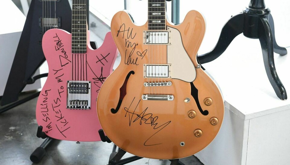 Guitaren til venstre er signeret af Machine Gun Kelly og den højre er signeret af Harry Styles.