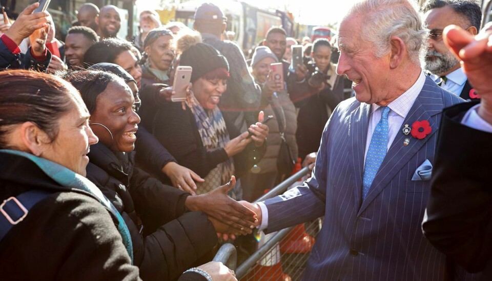 Prins Charles hilser på folkemængden efter mødet i sin fond torsdag den 11. november.