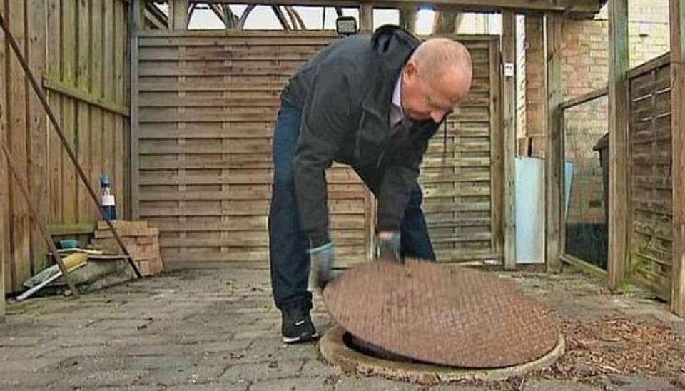 Frank Jeppesen løfter dækslet for at tjekke sit højvandslukke. Frank Jeppesen løfter dækslet for at tjekke sit højvandslukke.