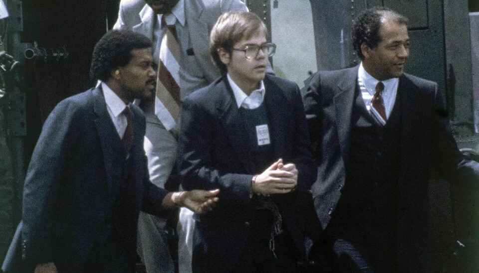 Her ses John Hinckley (i midten) i august 1981, hvor han bliver eskorteret af sikkerhedsagenter efter et retsmøde.