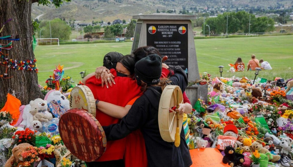Canadiere krammer foran et mindesmærke ved den tidligere kostskole Kamloops Indian Residential School. Her blev der i maj fundet 215 umærkede grave. (Arkivfoto.) Canadiere krammer foran et mindesmærke ved den tidligere kostskole Kamloops Indian Residential School. Her blev der i maj fundet 215 umærkede grave. (Arkivfoto.)