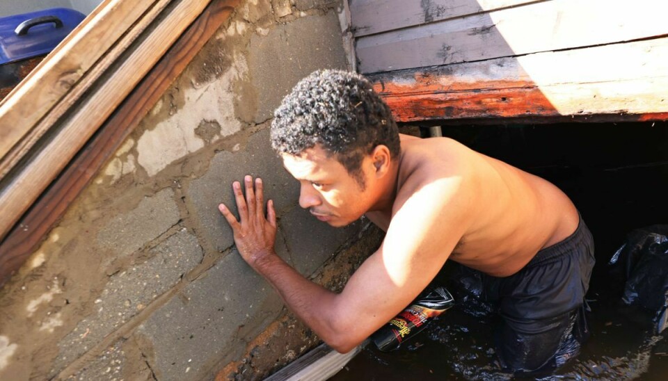 En beboer ved navn Luis Armejo er ved at installere et rør, der skal pumpe vand ud af hans kælder i Newark i New Jersey.