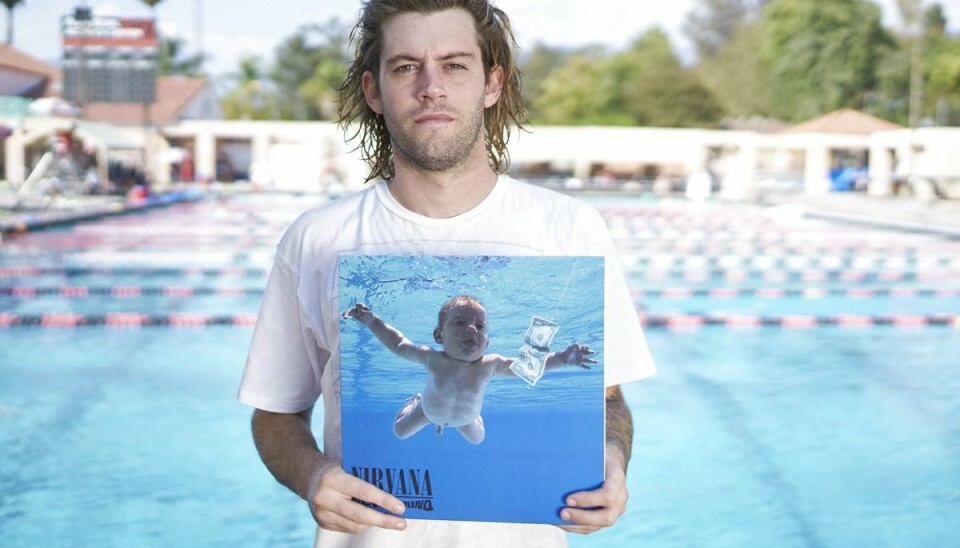 I dag 30-årige Spencer Elden med et eksemplar af coveret til Nirvana albummet 'Nevermind', hvor han selv er afbildet spilitternøgen i en swimmingpool som spæd. SplashNews.com Splash News and Pictures I dag 30-årige Spencer Elden med et eksemplar af coveret til Nirvana albummet 'Nevermind', hvor han selv er afbildet spilitternøgen i en swimmingpool som spæd. SplashNews.com Splash News and Pictures