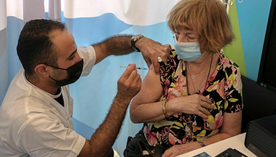 En israelsk sundhedsmedarbejder giver søndag det tredje stik med en coronavaccine til en borger over 60 år. I alt er der blevet givet knap en kvart million tredje vaccinedoser i Israel.