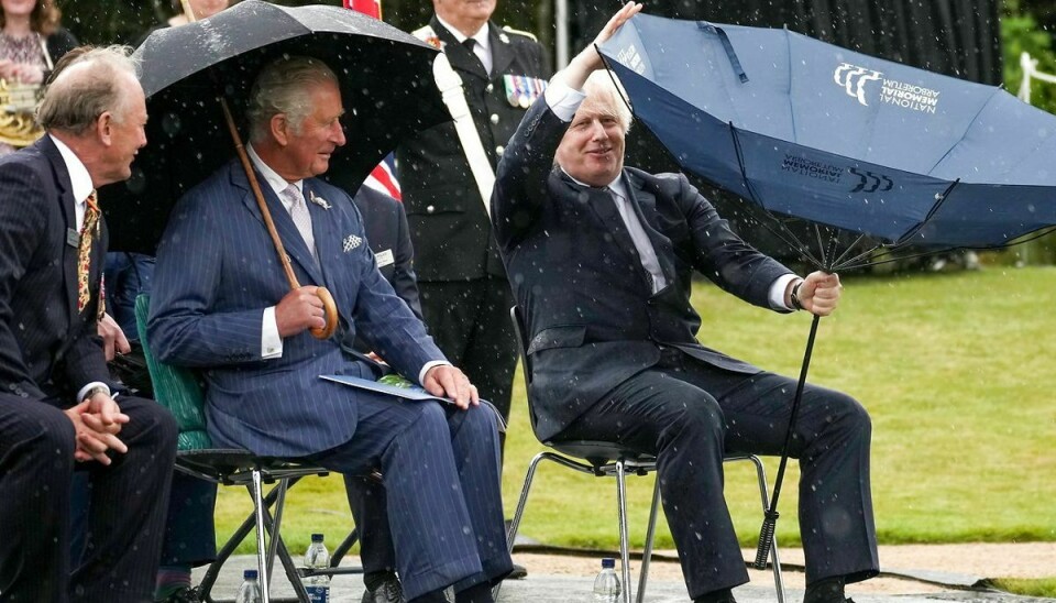 Prins Charles ser unægtelig til at 'hygge' sig gevaldigt over premierministerens kamp mod naturkræfterne. Foto: Scanpix/Christopher Furlong/Pool via REUTERS