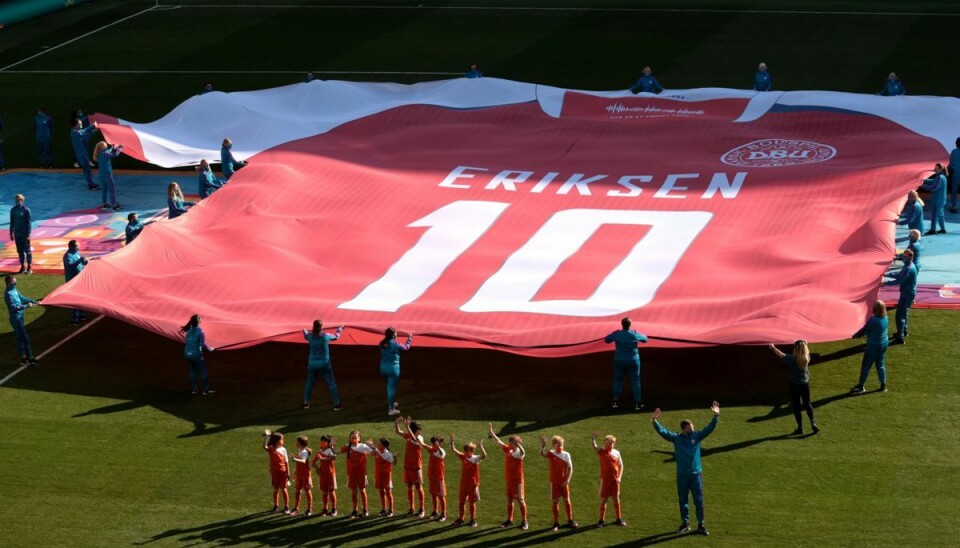En gigantisk Eriksen-trøje blev holdt over græsplænen kort før kampen mellem Danmark og Belgien i torsdags. En gigantisk Eriksen-trøje blev holdt over græsplænen kort før kampen mellem Danmark og Belgien i torsdags.