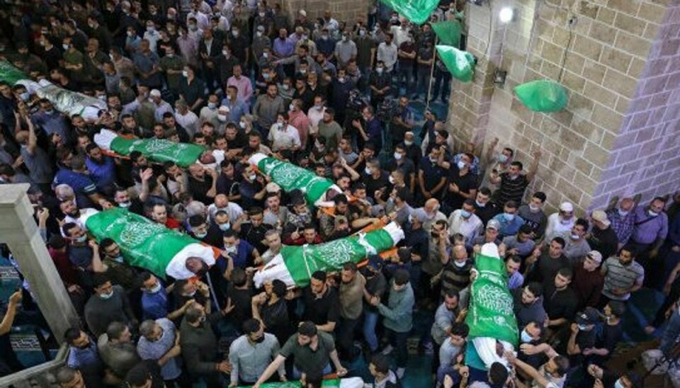 Palæstinensere i Gaza bærer ligene af 13 militante Hamas-medlemmer, der blev dræbt i israelske luftangreb, ved deres begravelser i Gaza City torsdag. Foto: Mahmud Hams/AFP