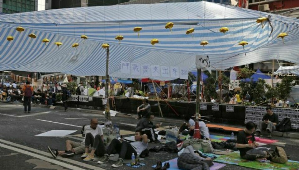 En gruppe demonstranter i Hongkong ved en af de blokerede gader lørdag. Mandag er Hongkongs politi begyndt af fjerne barrikaderne. Foto: Vincent Yu/AP